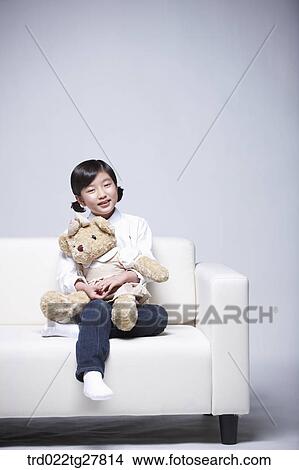 children education girl hugging teddy bear on couch View Large Photo Image Picture - children education girl hugging teddy bear on couch. Fotosearch