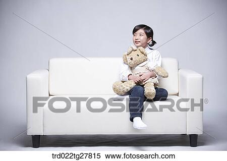 children education girl hugging teddy bear on couch View Large Photo Image Stock Photography - children education girl hugging teddy bear on couch. Fotosearch