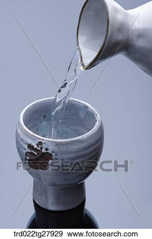 Stock Photo - pour sake into glass. Fotosearch