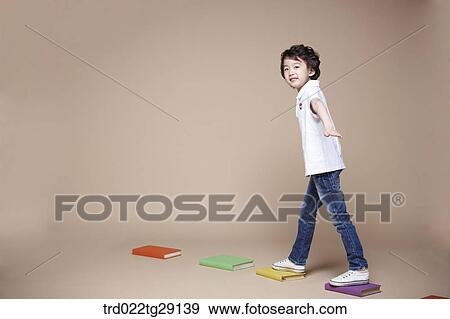 Stock Photo - boy crosses stepping stones. Fotosearch