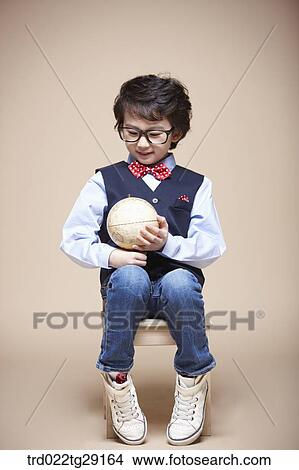 Picture - boy holding globe. Fotosearch