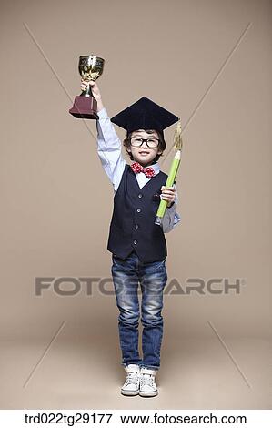 boy pick up the trophy wearing graduation cap View Large Photo Image Stock Photo - boy pick up the trophy wearing graduation cap. Fotosearch