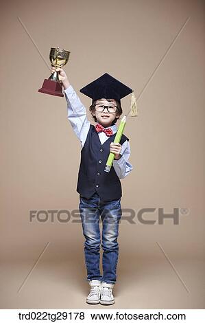 boy pick up the trophy wearing graduation cap View Large Photo Image Stock Photo - boy pick up the trophy wearing graduation cap. Fotosearch