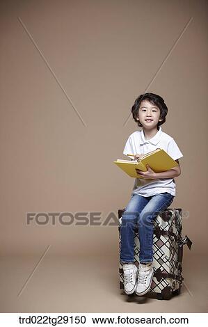 boy reading a book sitting on carrier View Large Photo Image Stock Image - boy reading a book sitting on carrier. Fotosearch