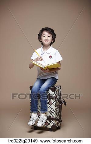 boy reading a book sitting on carrier View Large Photo Image Stock Photo - boy reading a book sitting on carrier. Fotosearch