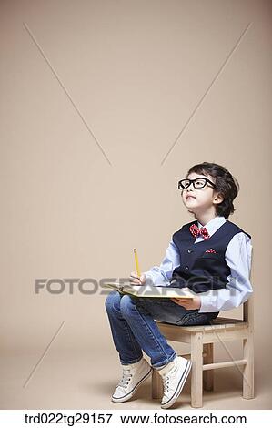 Stock Photo - boy studying on chair. Fotosearch