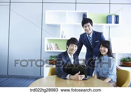 Stock Image - business people working together seeing laptop. Fotosearch