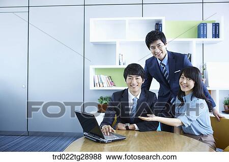Stock Photo - business people working together seeing laptop. Fotosearch