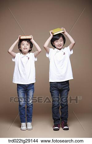 children balancing a book on their head View Large Photo Image Picture - children balancing a book on their head. Fotosearch