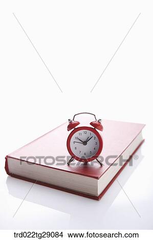 Picture - clock on the book. Fotosearch