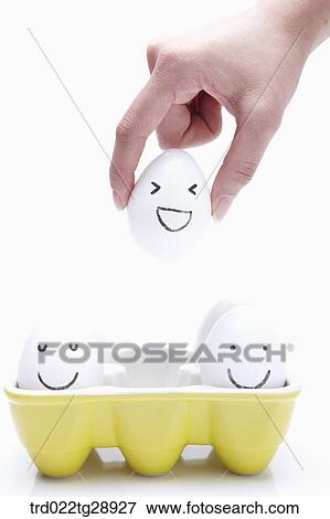 Stock Photo - finger picks egg up . Fotosearch