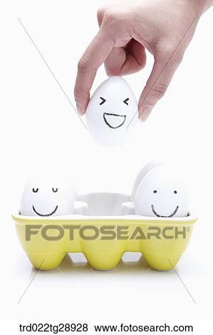Stock Photo - finger picks egg up . Fotosearch