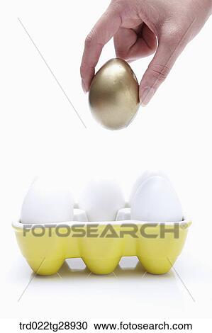 Stock Image - finger picks golden egg up . Fotosearch