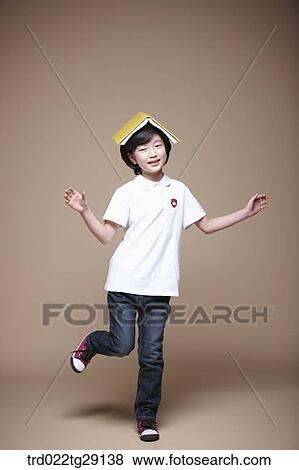 girl jumping and balancing a book on her head View Large Photo Image Stock Photo - girl jumping and balancing a book on her head. Fotosearch