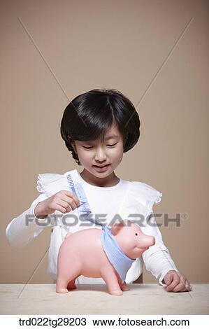 girl put the money into piggy bank View Large Photo Image Stock Image - girl put the money into piggy bank. Fotosearch