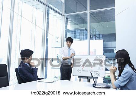 Stock Photo - man doing presentation to people in meeting room. Fotosearch