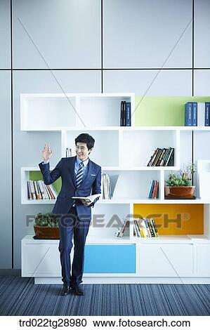 Stock Image - man holding book in office. Fotosearch