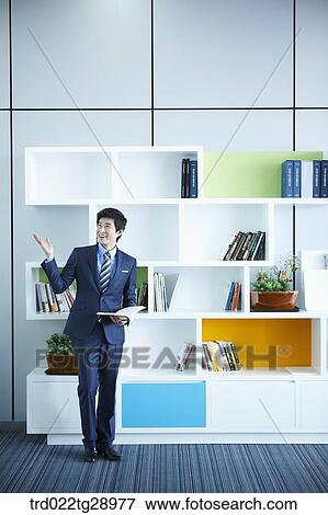 man holding book in office View Large Photo Image Stock Photo - man holding book in office. Fotosearch