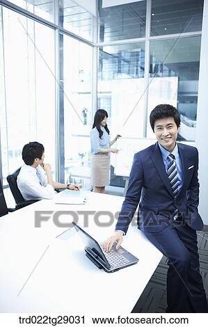 Stock Image - woman doing presentation to people in meeting room. Fotosearch