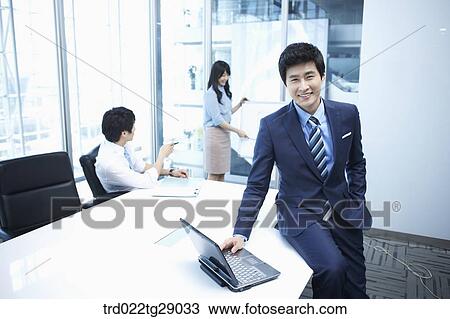 Stock Image - woman doing presentation to people in meeting room. Fotosearch