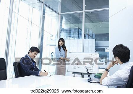 Stock Photograph - woman doing presentation to people in meeting room. Fotosearch