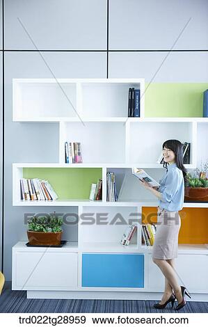 woman reads book by the bookshelf View Large Photo Image Stock Photo - woman reads book by the bookshelf. Fotosearch