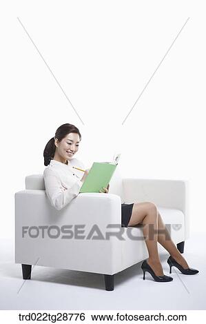 woman reads book on the sofa View Large Photo Image Stock Photograph - woman reads book on the sofa. Fotosearch