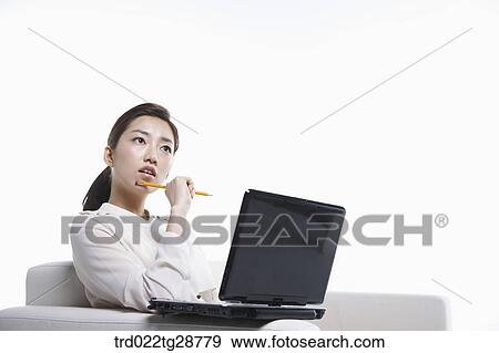 Stock Photo - woman using laptop on the sofa. Fotosearch