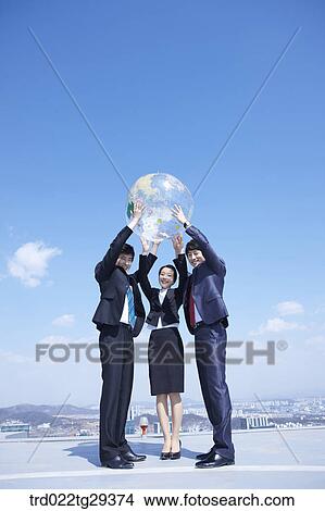 business people raise the globe View Large Photo Image Picture - business people raise the globe. Fotosearch