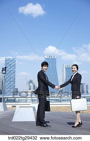 Stock Image - business people shaking hands together. Fotosearch