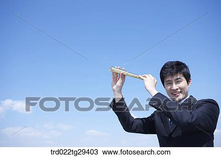Stock Image - businessman see the scape through the telelscope. Fotosearch