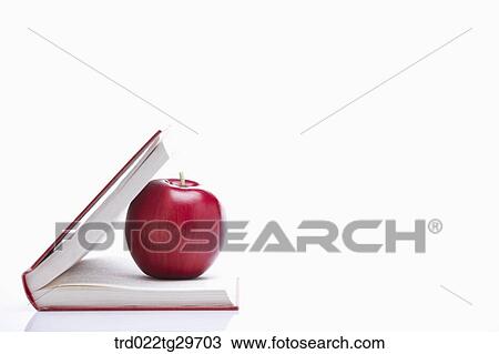 Stock Image - apple on the opened book. Fotosearch