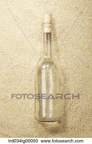 Stock Image - bottle on sand. Fotosearch