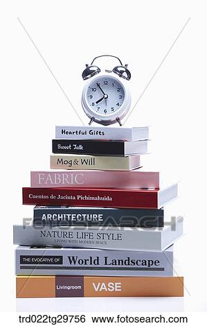 Stock Photograph - clock on the piled books. Fotosearch