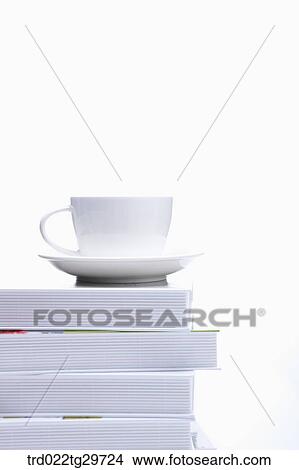 Picture - coffee cup on piled books. Fotosearch