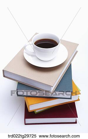 Stock Photography - coffee cup on piled books. Fotosearch