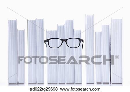 Stock Photo - glasses on the piled books. Fotosearch