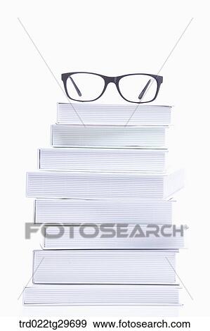 Stock Photo - glasses on the piled books. Fotosearch