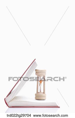 hourglass on the pages of the book View Large Photo Image Picture - hourglass on the pages of the book. Fotosearch