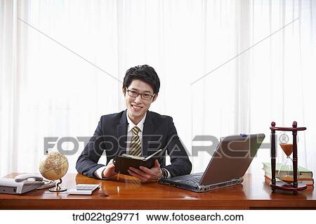 Stock Image - man checks his schedule through schedule book. Fotosearch
