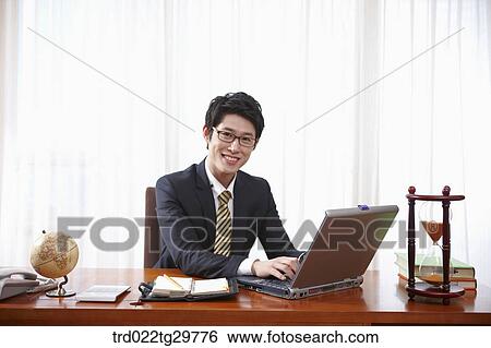 Stock Photograph - man doing his work on the desk. Fotosearch