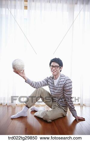 man holding globe sitting on floor View Large Photo Image Stock Image - man holding globe sitting on floor. Fotosearch