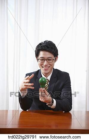 Stock Image - man holding light bulb. Fotosearch