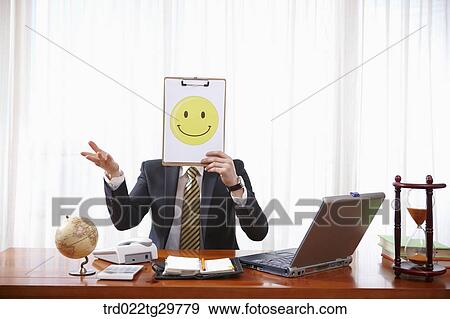 Stock Photo - man holding paper which has smile face. Fotosearch