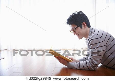 Stock Photography - man lied face down and reads book. Fotosearch