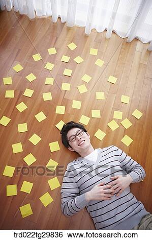 man lied on the floor which has memo pad on it View Large Photo Image Stock Photograph - man lied on the floor which has memo pad on it. Fotosearch