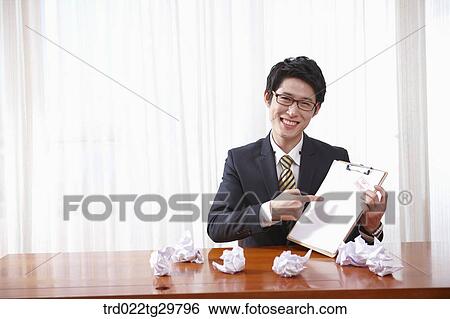 Stock Photograph - man points at the paper. Fotosearch