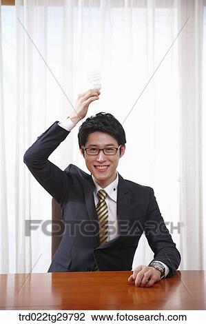 Stock Image - man raise the light bulb. Fotosearch