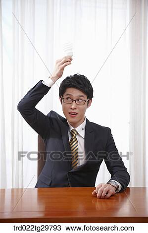 Stock Image - man raise the light bulb. Fotosearch