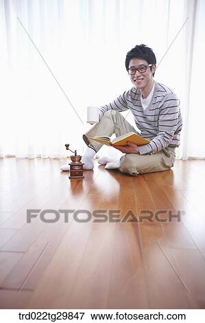 Stock Photo - man reading book drinkin coffee. Fotosearch